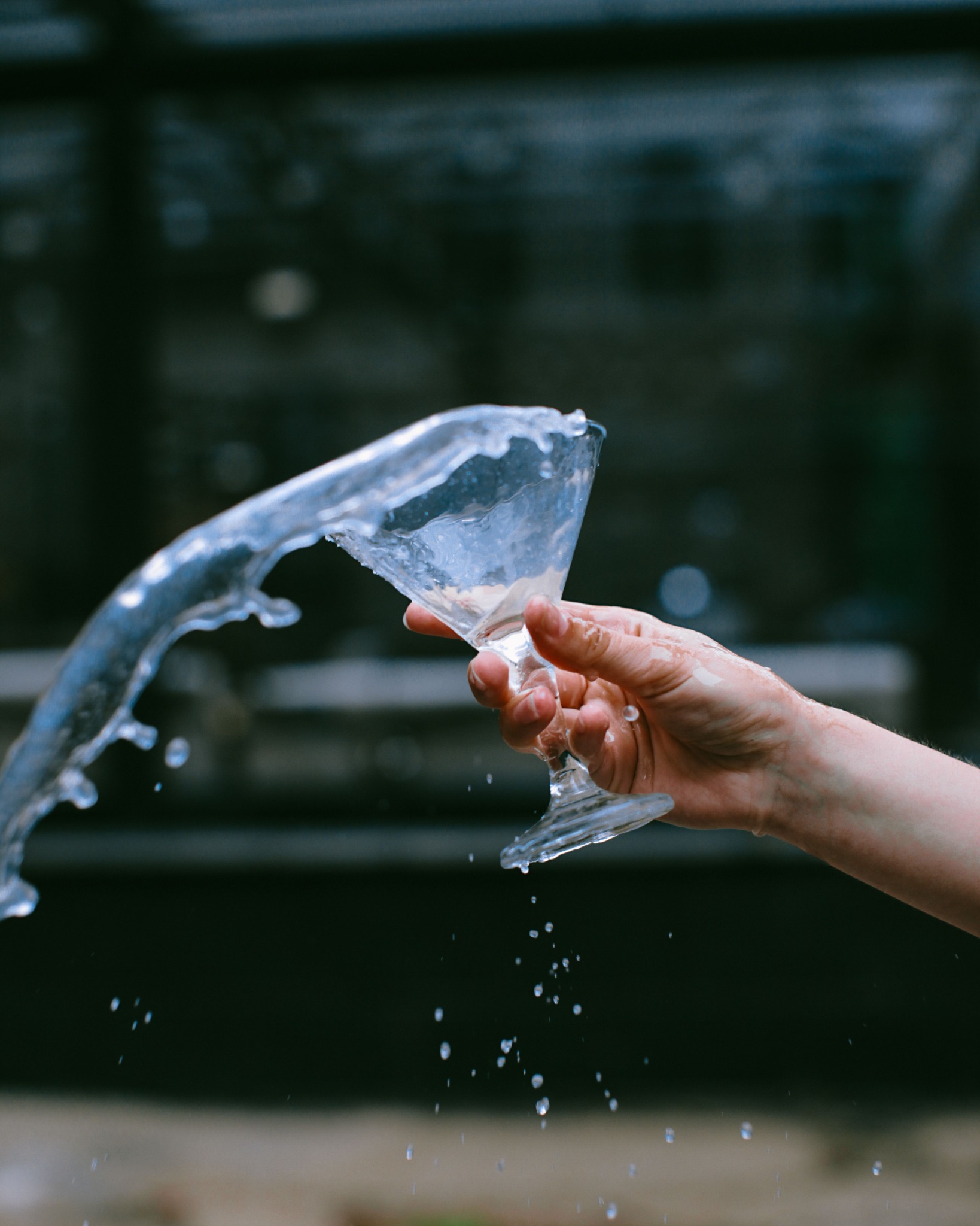 Water splashing out of a glass held in one hand