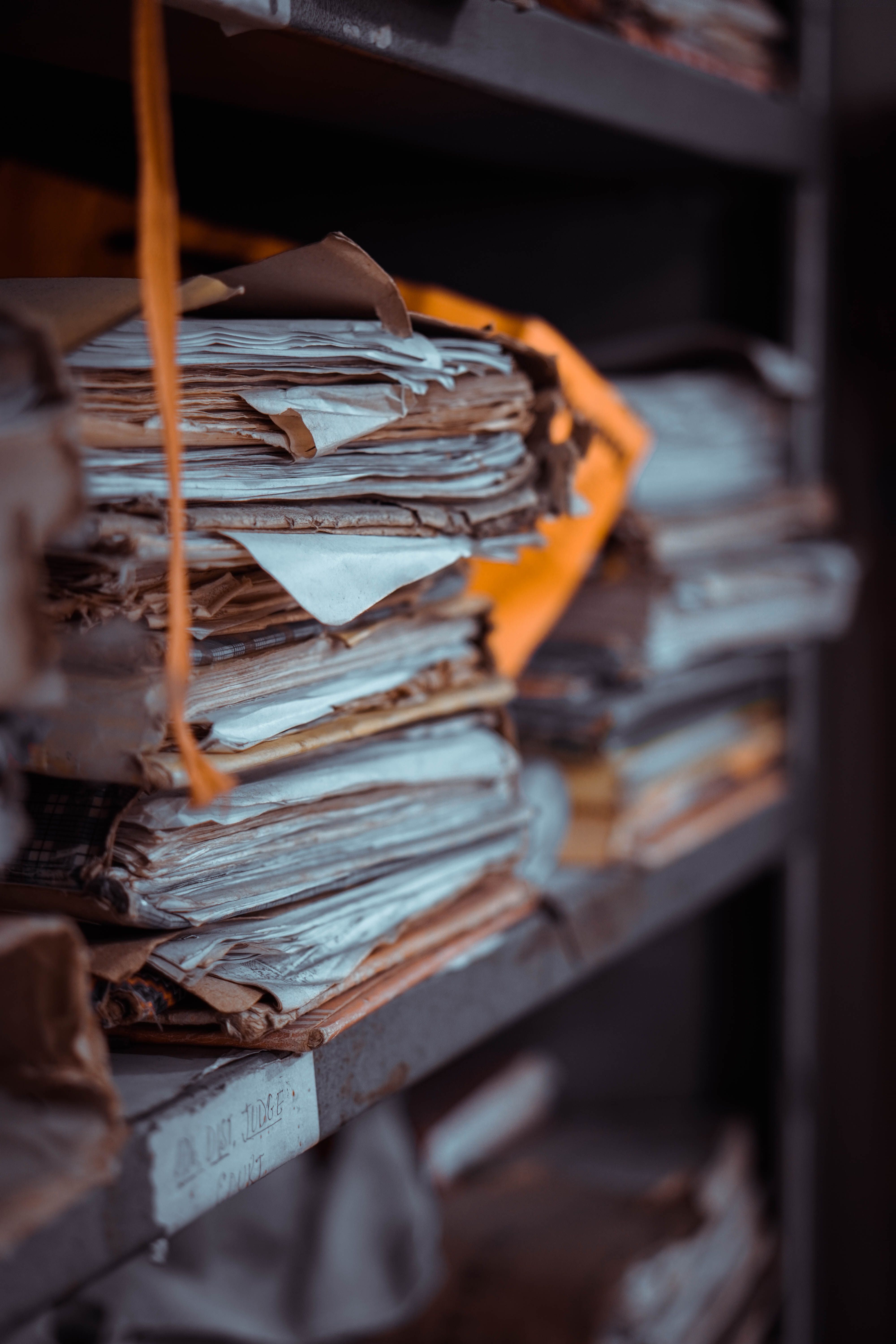 Stacks of old documents and papers piled on dusty shelves